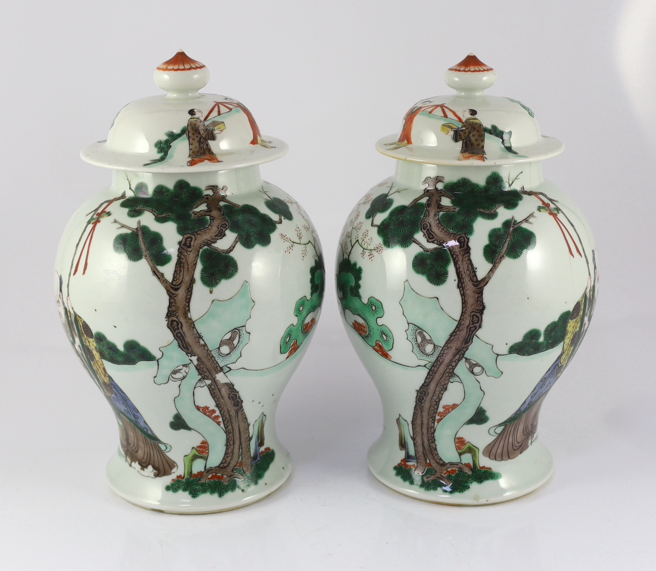 A pair of Chinese famille verte ‘Sanxing’ vases and covers, 19th century, some cracks